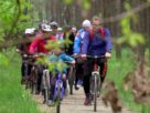Uczestnicy rajdu rowerowego pokonują leśną ścieżkę